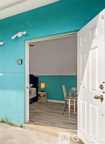 A white door is open to a room with a blue wall.
