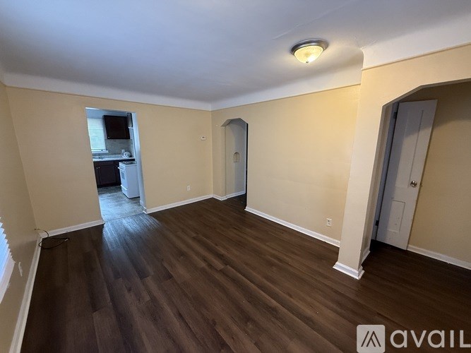 A room with wooden flooring and a window.