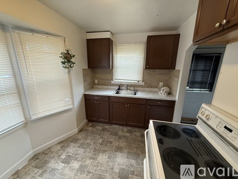 A kitchen with a tiled floor and a stove top oven.