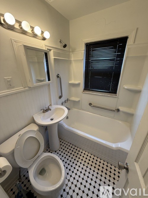 A white toilet sits in a bathroom with a black and white checkered floor.