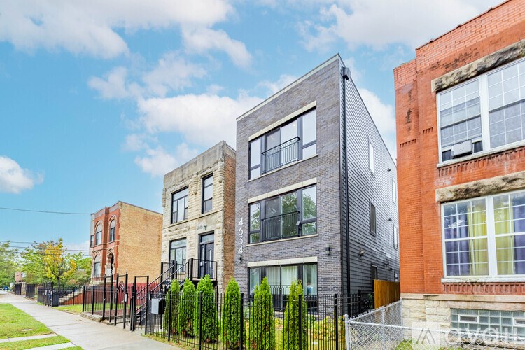 A row of modern townhouses with a clear blue sky above them.