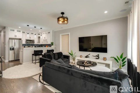 A modern living room with a black couch and a television.