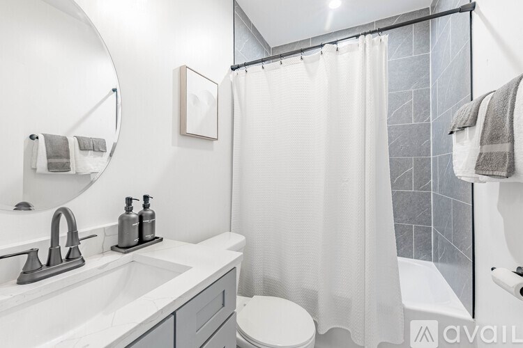 A bathroom with a white sink, toilet, and shower curtain.