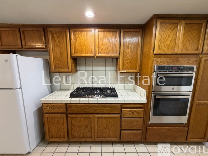 A kitchen with wooden cabinets and a white fridge.