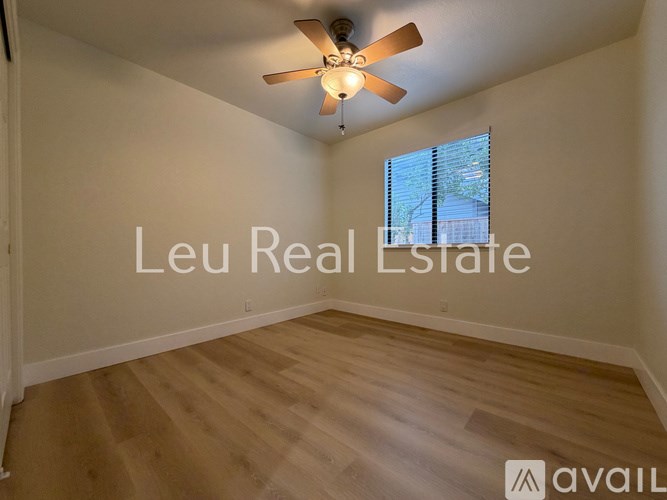 A room with a ceiling fan and wooden flooring is available for rent.