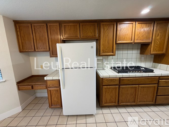 A kitchen with a white fridge and wooden cabinets.