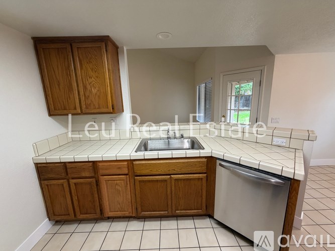 A kitchen with wooden cabinets and a stainless steel dishwasher.