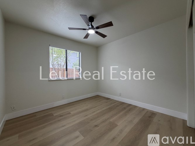 A room with a ceiling fan and wooden flooring is available for real estate.
