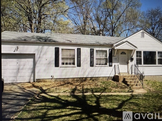 A house with a garage and a front porch is for sale.