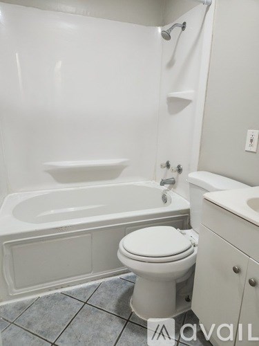 A white toilet sits next to a bathtub in a bathroom.
