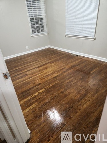 A room with wooden flooring and a white door.