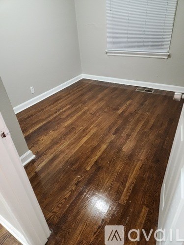 A room with wooden flooring and a white door.