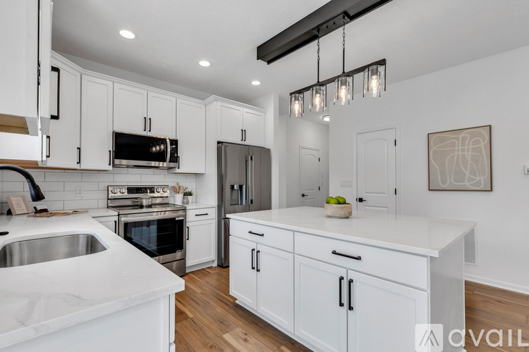 A modern kitchen with white cabinets and a stainless steel sink.