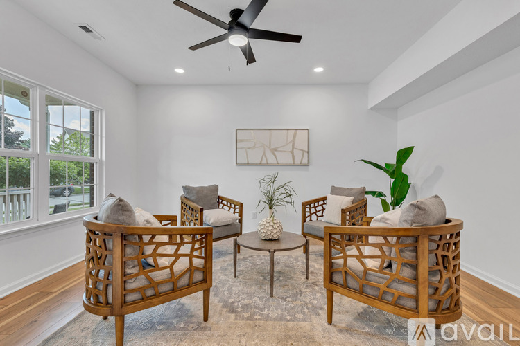A living room with a ceiling fan and a painting on the wall.