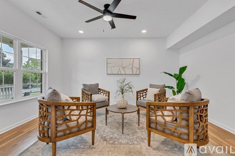 A living room with a ceiling fan and a painting on the wall.