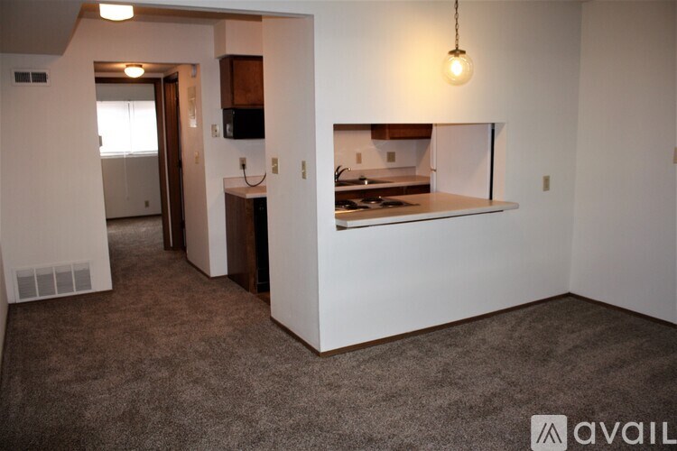 A small kitchen with a countertop and a single light bulb hanging from the ceiling.