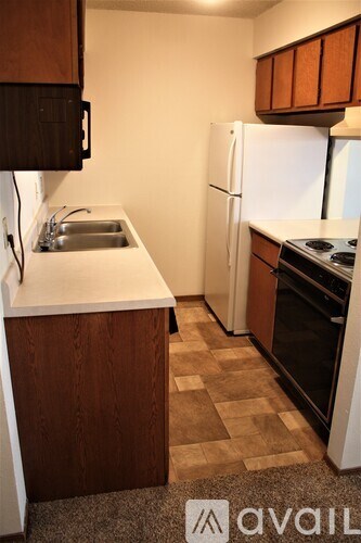 A kitchen with a white fridge and a white sink.