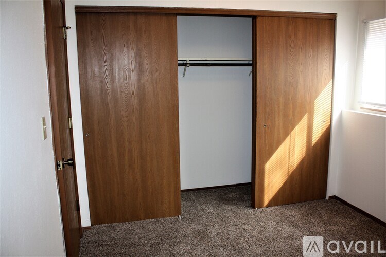 A room with a brown door and a grey carpet.