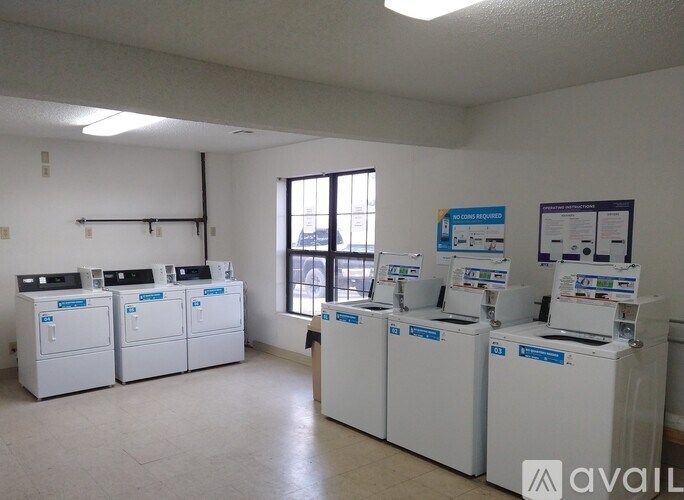 A room with white appliances and a window.