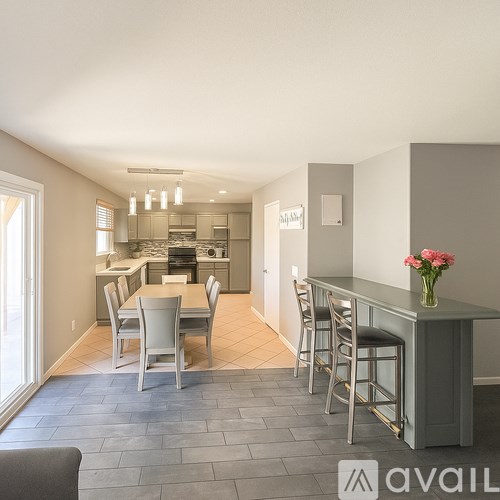 A kitchen with a dining table and chairs in the foreground.
