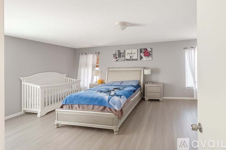A bedroom with a bed, a crib, and a dresser.
