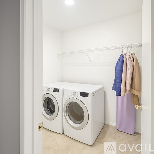 Two white front loading washing machines in a laundry room.