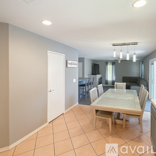 A dining room with a table and chairs.