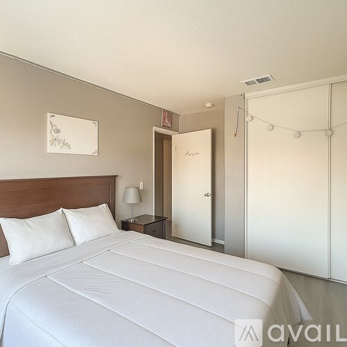 A bedroom with a large bed and a white door.