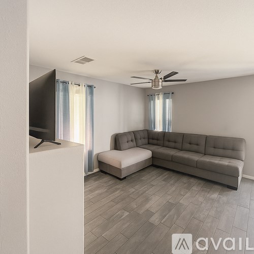 A living room with a grey sofa and a television.