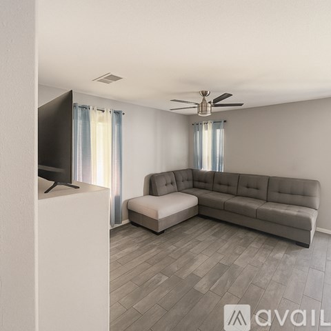 A living room with a grey sofa and a television.