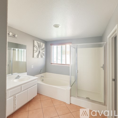 A bathroom with a white sink and a bathtub with a glass door.