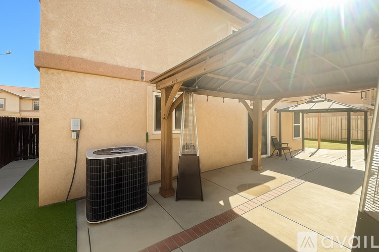 A patio area with a sun umbrella and a wall-mounted air conditioning unit.
