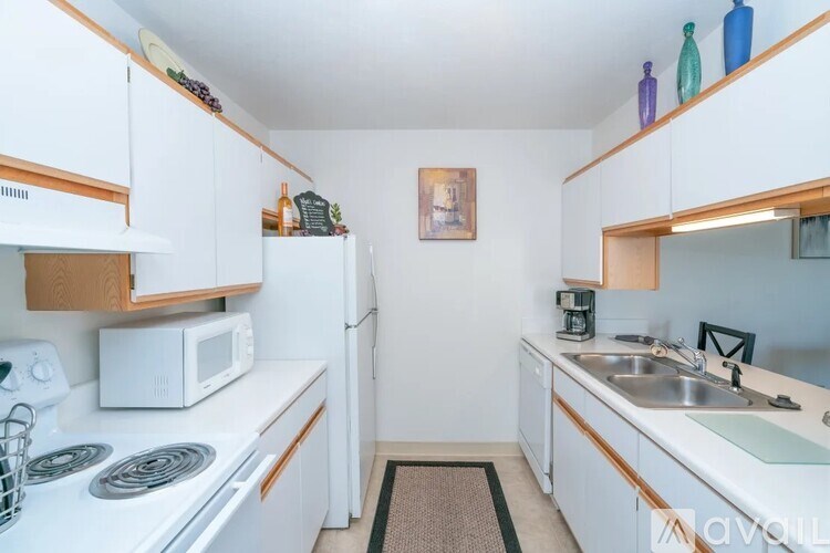 A kitchen with white cabinets and a white stove top oven.