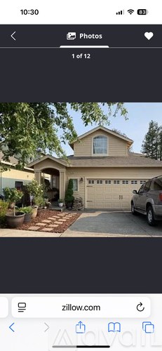 A house with a garage and a car parked in front.