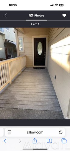 A wooden deck leads to a black door with a glass window.