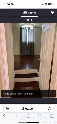 A hallway with a wooden floor and a white door.