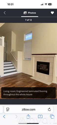 A living room with a fireplace and engineered laminated flooring.