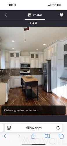 A kitchen with granite countertops and white cabinets.