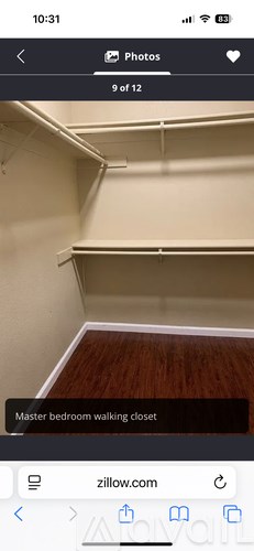 A white closet with a wooden floor and a white wall.