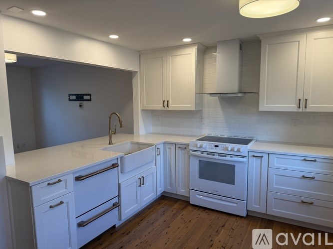 A modern kitchen with white cabinets and appliances.