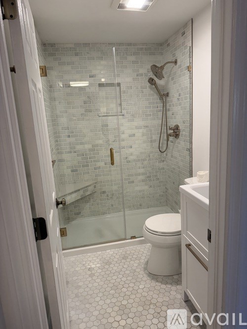 A bathroom with a white toilet and a glass shower stall.