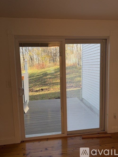 A sliding glass door with a view of a backyard.
