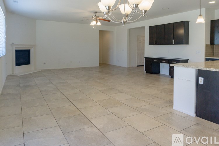 A spacious living room with a kitchen area in the background.