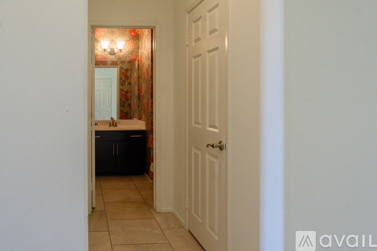 A hallway with a door on the right and a doorway on the left.