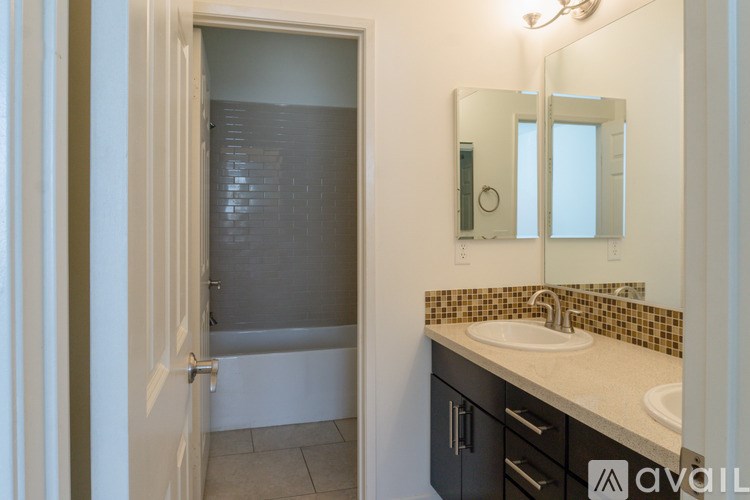 A bathroom with a sink, mirror, and shower.