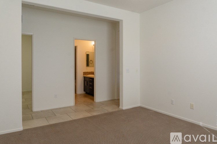 A room with a carpeted floor and a doorway leading to another room.
