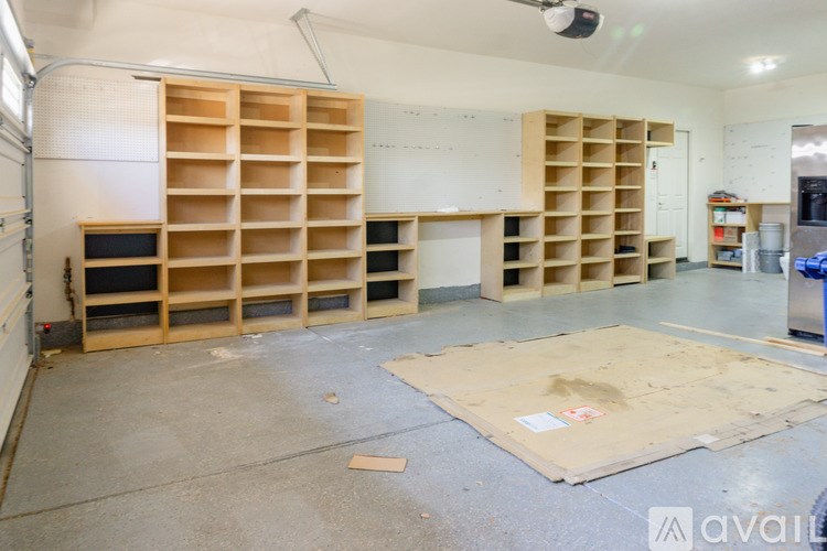 A room with a lot of empty shelves and a concrete floor.