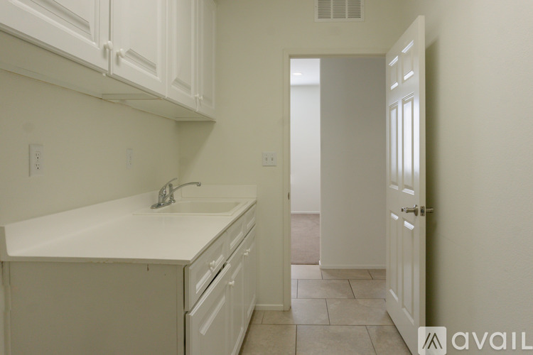 A kitchen with white cabinets and a white sink.