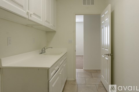 A kitchen with white cabinets and a white sink.
