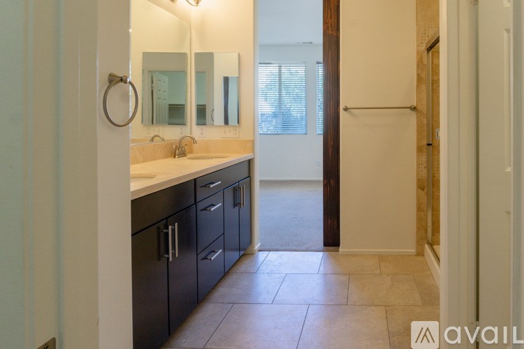 A bathroom with a sink, mirror, and cabinets.